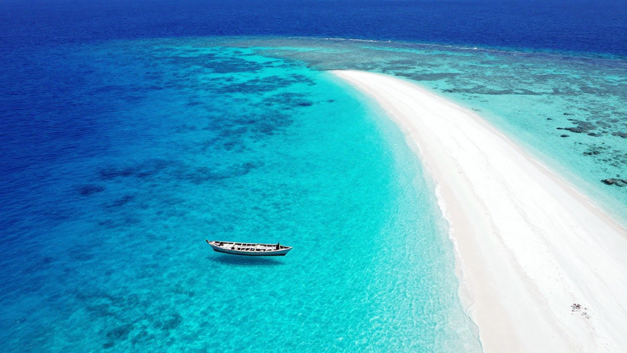 Aerial view of a neon-blue coral atoll lagoon with a floating boat in Lakshadweep.